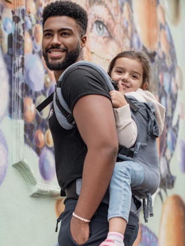 papa porteando a niña grande en la mochila de porteo Quokkababy E CARRIER